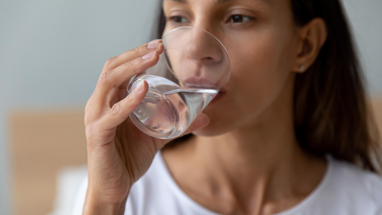 Eine Frau trinkt Wasser aus einem Glas.