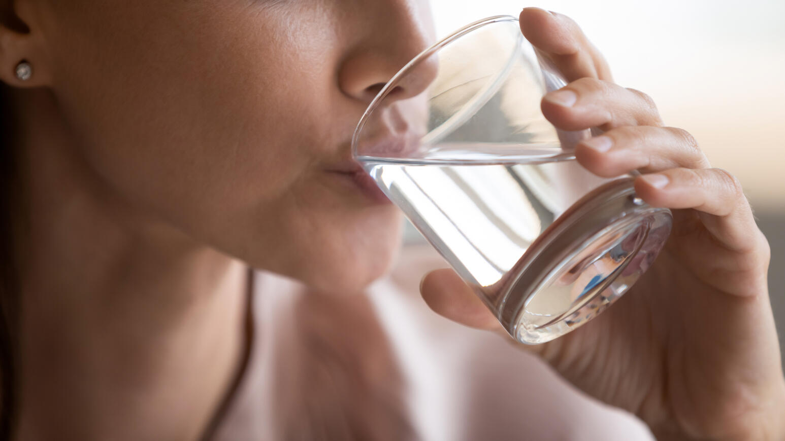 Eine Frau trinkt Wasser aus einem Glas.