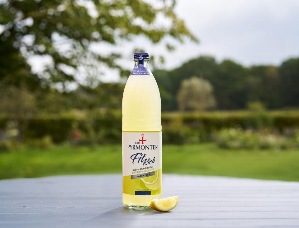 Bad Pyrmonter Fit Kick Zitrone Grapefruit auf einem Holztisch vor Naturhintergrund.