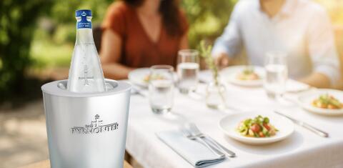 Flasche Bad Pyrmonter Mineralwasser in einem Kühler auf einem Tisch im Restaurant.