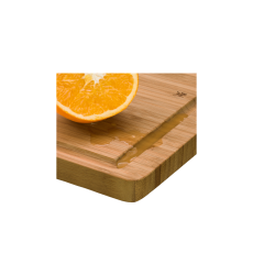 Bambus-Schneidebrett mit Saftrille, darauf eine halbierte Orange und ausgelaufener Saft.