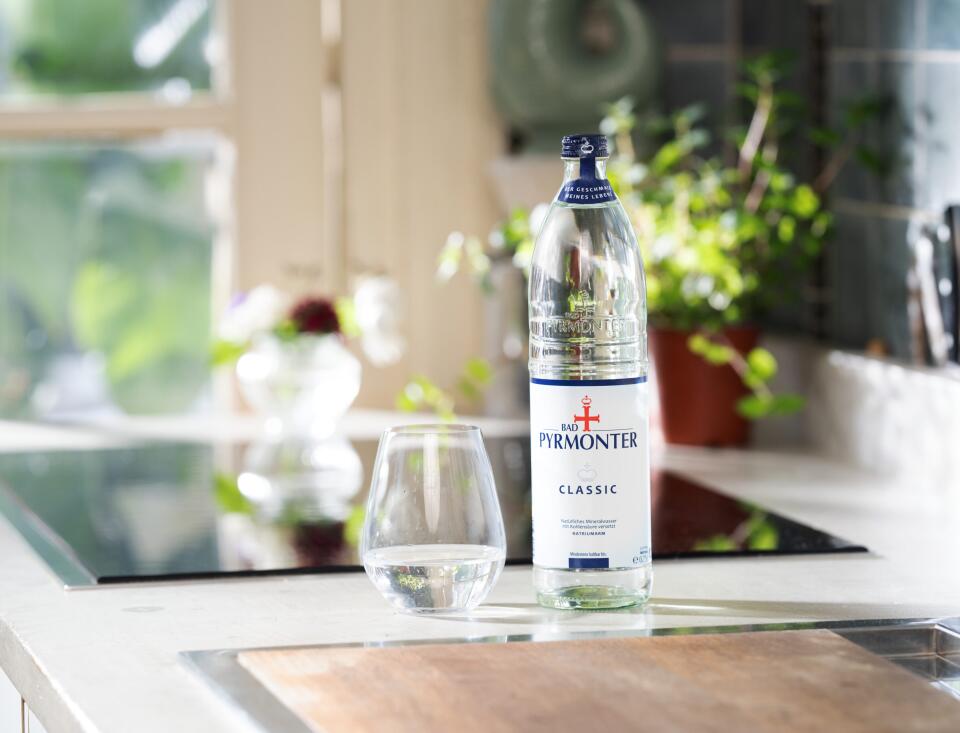 Bad Pyrmonter Mineralwasser Classic mit Glas auf einer modernen Küchenzeile.