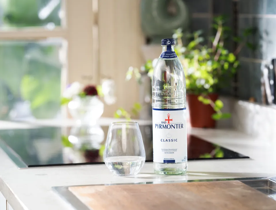 Bad Pyrmonter Mineralwasser Classic mit Glas auf einer modernen Küchenzeile.