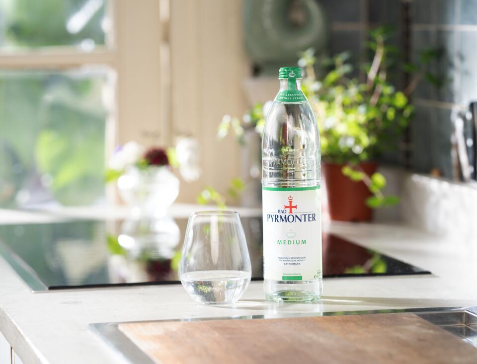 Bad Pyrmonter Mineralwasser Medium mit Glas auf einer modernen Küchenzeile.