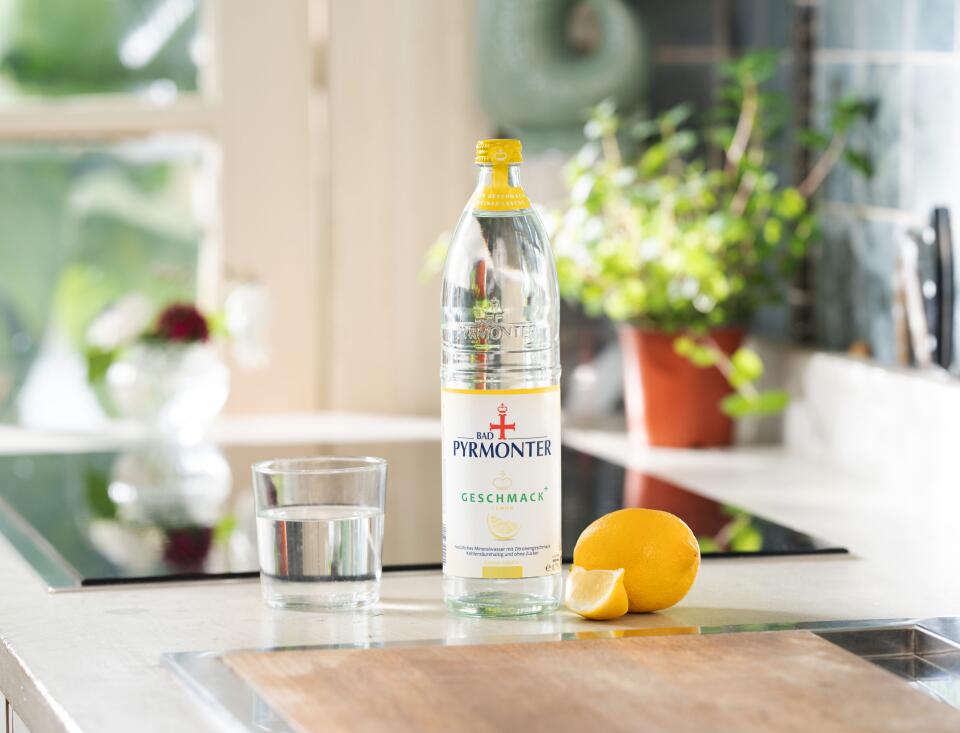 Bad Pyrmonter Mineralwasser Geschmack Plus Lemon mit Glas auf einer modernen Küchenzeile.