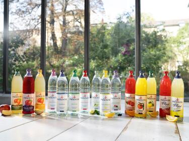 Alle Bad Pyrmonter Produkte in Glasflaschen auf einem Tisch vor einer großen Fensterfassade