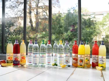 Alle Bad Pyrmonter Produkte in Glasflaschen auf einem Tisch vor einer großen Fensterfassade