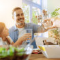 Eine Familie am Esstisch, die mit Wassergläsern anstößt